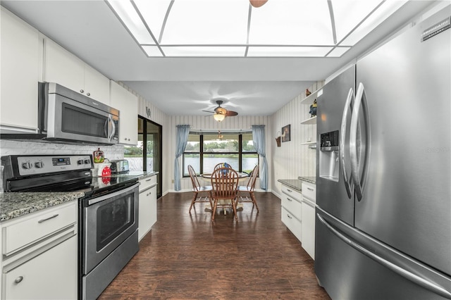 kitchen with light stone counters, white cabinets, appliances with stainless steel finishes, backsplash, and dark wood-style floors