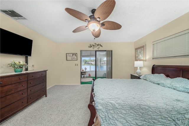 bedroom featuring a textured ceiling, light carpet, visible vents, baseboards, and access to outside