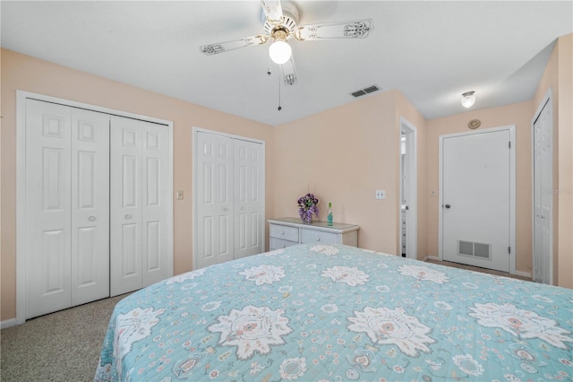 bedroom featuring multiple closets, visible vents, and a ceiling fan