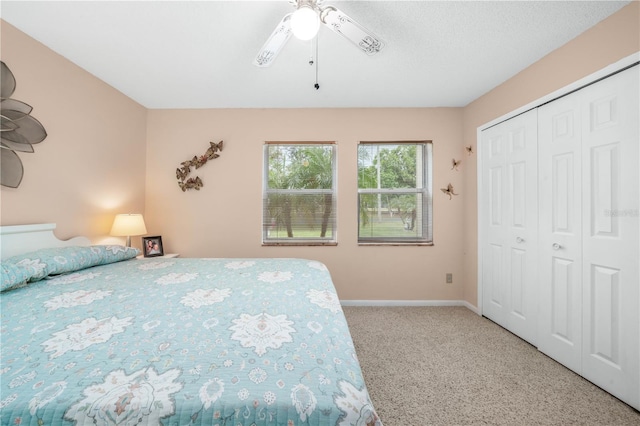 carpeted bedroom with a closet, a ceiling fan, and baseboards