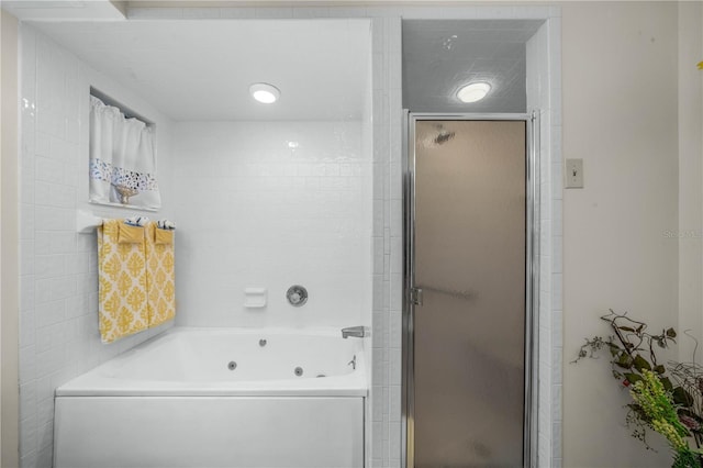 bathroom with a whirlpool tub and a shower stall