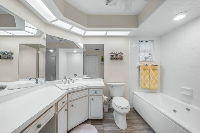 bathroom with a ceiling fan, toilet, wood finished floors, a washtub, and vanity