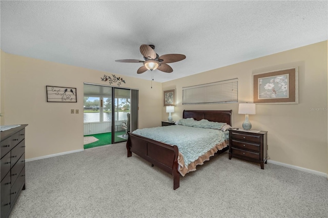 bedroom with a textured ceiling, baseboards, light colored carpet, and access to exterior