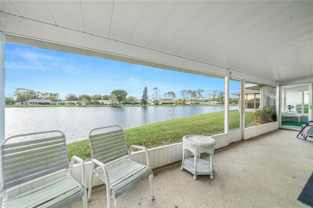 sunroom featuring a water view