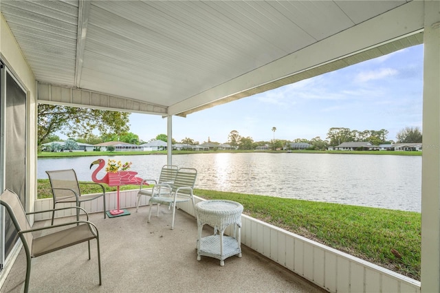 sunroom / solarium with a water view and vaulted ceiling