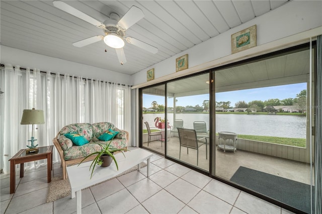 sunroom / solarium featuring a ceiling fan, a healthy amount of sunlight, and a water view