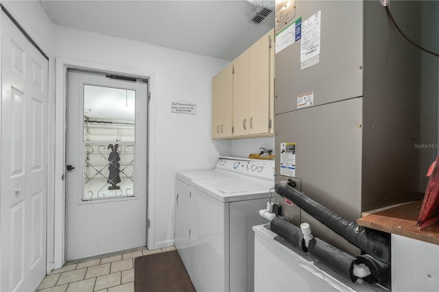 laundry room with cabinet space, visible vents, washer and dryer, and light tile patterned flooring