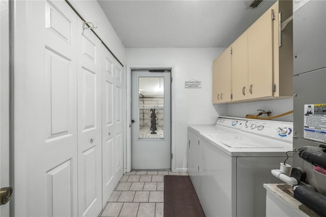 laundry area featuring light tile patterned floors, visible vents, cabinet space, and washer and dryer