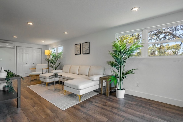 living room featuring recessed lighting, an AC wall unit, baseboards, and wood finished floors