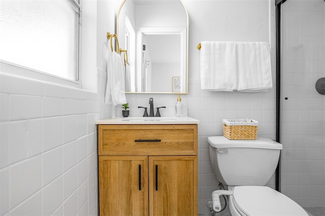 full bath featuring toilet, a tile shower, tile walls, and vanity