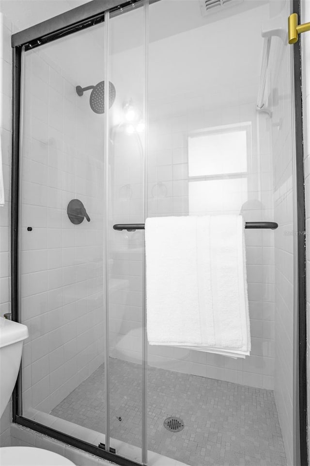 bathroom with a shower stall and toilet