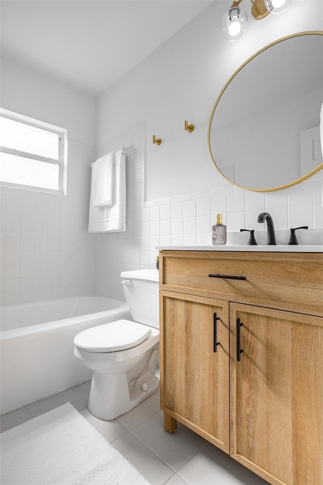 bathroom featuring tile walls, toilet, a bathing tub, vanity, and tile patterned floors