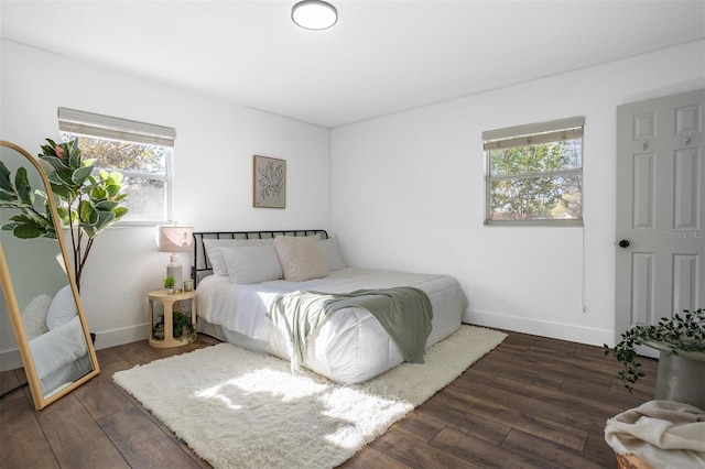 bedroom with baseboards and wood finished floors