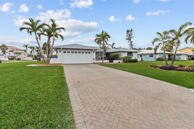 ranch-style house with an attached garage, a residential view, decorative driveway, and a front yard