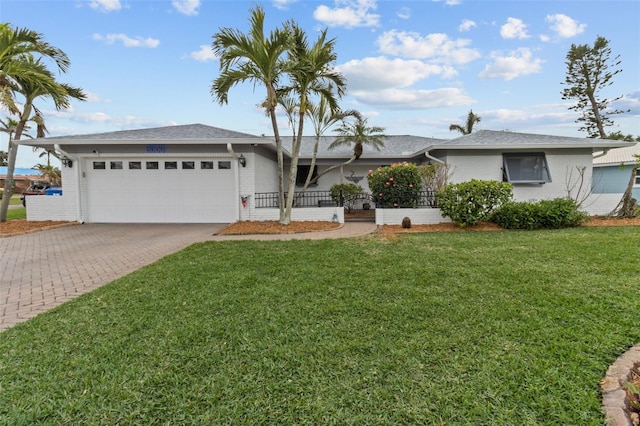 ranch-style house featuring a garage, decorative driveway, brick siding, and a front lawn