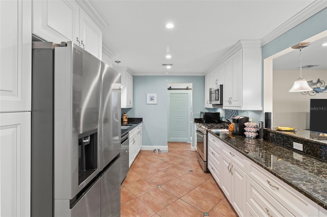 kitchen with appliances with stainless steel finishes, white cabinets, hanging light fixtures, and a barn door