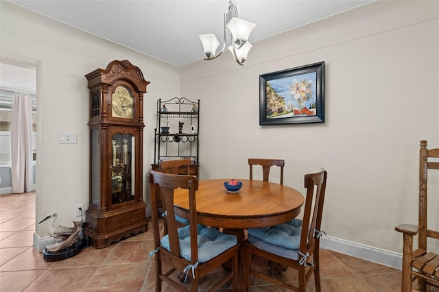 dining area featuring tile patterned flooring, baseboards, and a notable chandelier