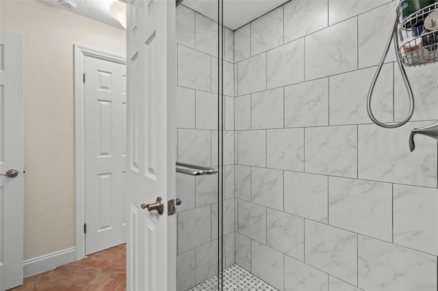 full bathroom with a shower stall and baseboards