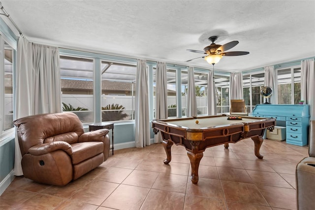 rec room with a textured ceiling, pool table, ceiling fan, and tile patterned flooring