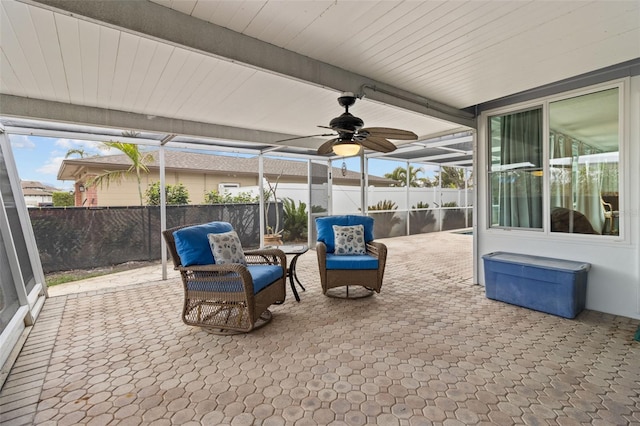 sunroom featuring ceiling fan and beamed ceiling