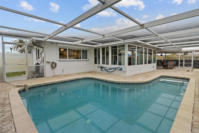 pool with glass enclosure, a patio area, and fence