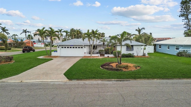 single story home with a garage, a residential view, driveway, and a front lawn