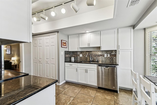 kitchen with a sink, visible vents, white cabinets, stainless steel dishwasher, and backsplash