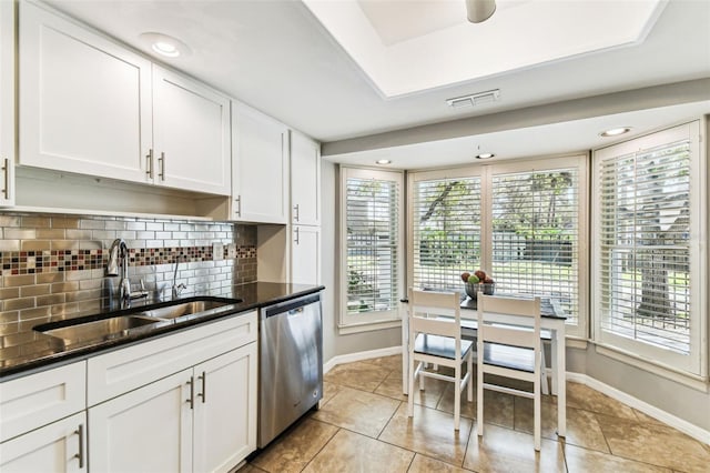 kitchen with tasteful backsplash, visible vents, white cabinets, stainless steel dishwasher, and a sink