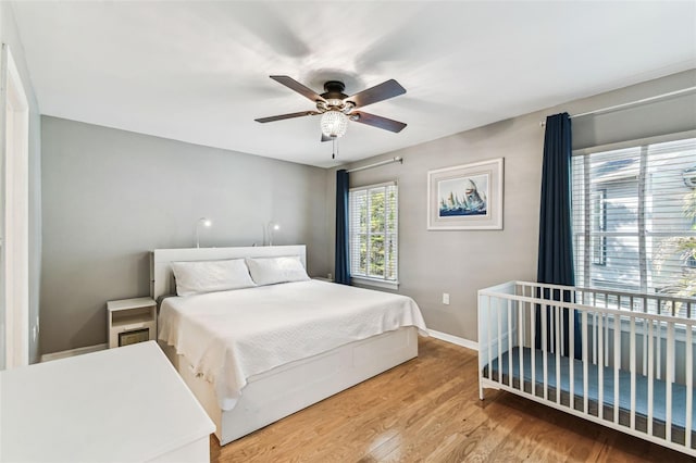 bedroom with a ceiling fan, baseboards, and wood finished floors