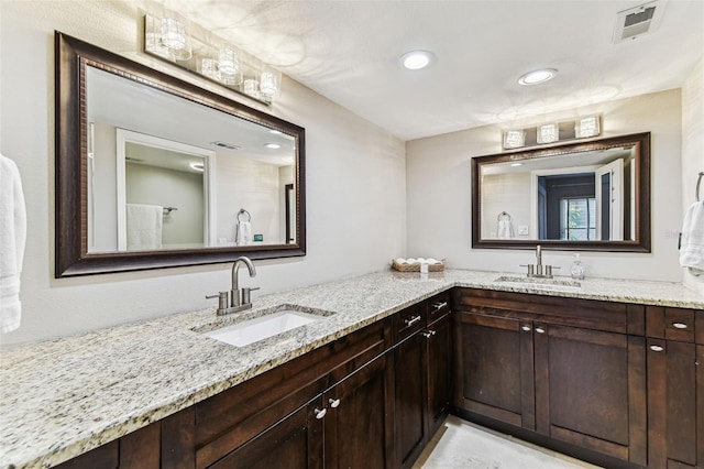 bathroom with visible vents, a sink, and double vanity