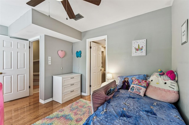 bedroom featuring a ceiling fan, visible vents, light wood-style flooring, and baseboards