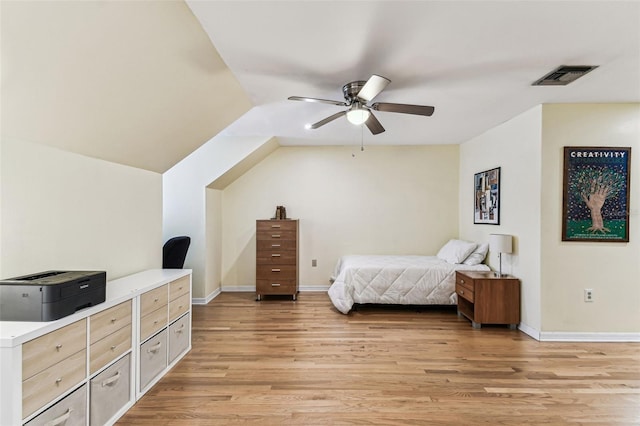 bedroom featuring vaulted ceiling, light wood-style flooring, visible vents, and baseboards