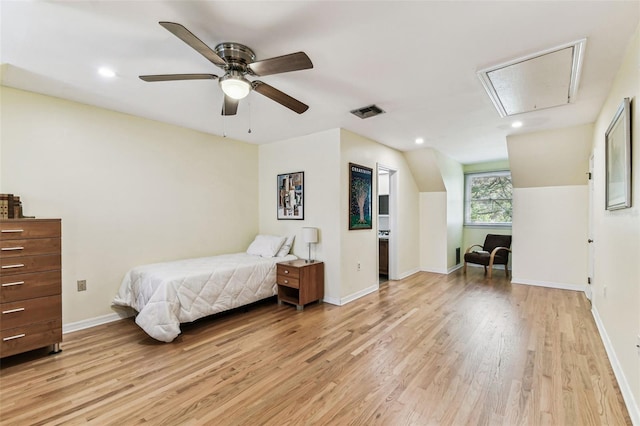 bedroom with light wood-type flooring, attic access, visible vents, and baseboards