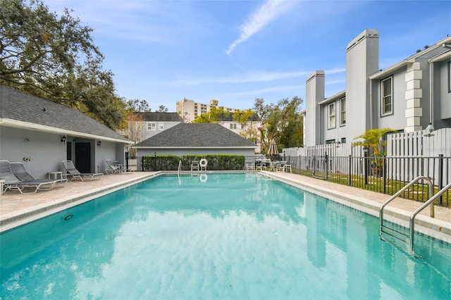 pool with a patio area and fence