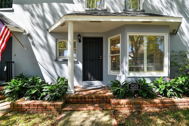 doorway to property with stucco siding and a porch
