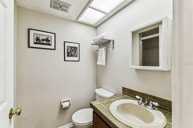 bathroom featuring toilet, vanity, and a shower