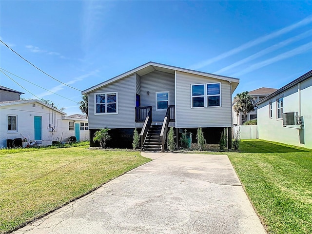 view of front of house with a front yard, fence, central air condition unit, and stairs