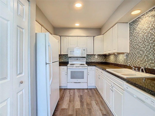 kitchen with white appliances, a sink, white cabinetry, and tasteful backsplash