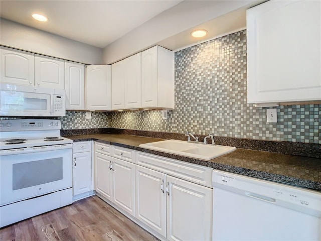 kitchen featuring backsplash, light wood-style floors, white cabinetry, a sink, and white appliances