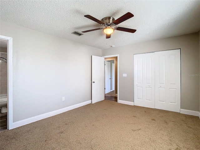 unfurnished bedroom with carpet, a closet, visible vents, a textured ceiling, and baseboards