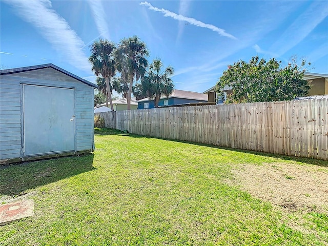 view of yard featuring a shed, a fenced backyard, and an outdoor structure