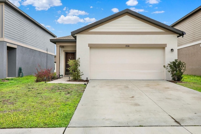 view of front of house with a garage, a front lawn, concrete driveway, and stucco siding