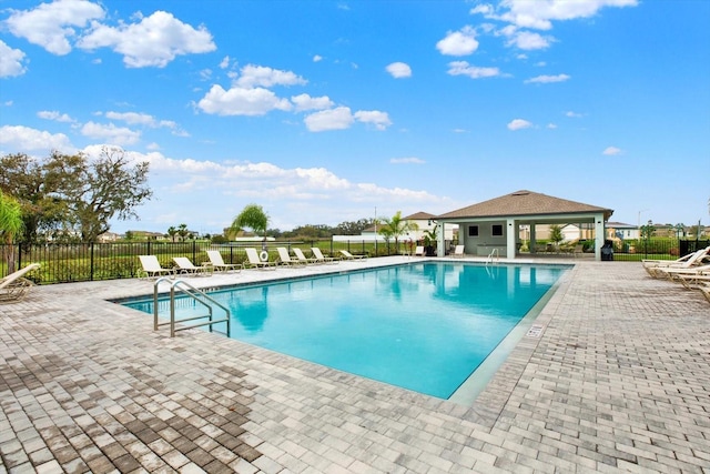 pool with a patio area, fence, and a gazebo