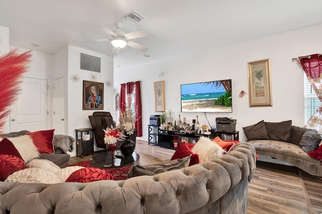 living area featuring visible vents, ceiling fan, and wood finished floors