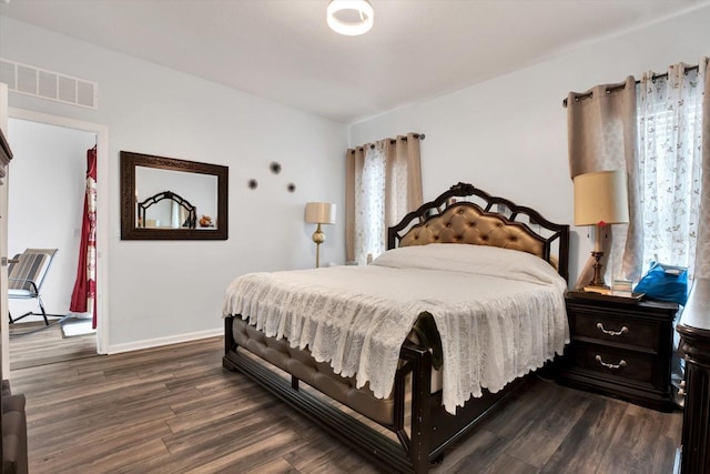 bedroom with dark wood-type flooring, visible vents, and baseboards