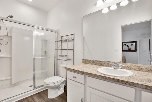 full bath with visible vents, toilet, wood finished floors, vanity, and a shower stall