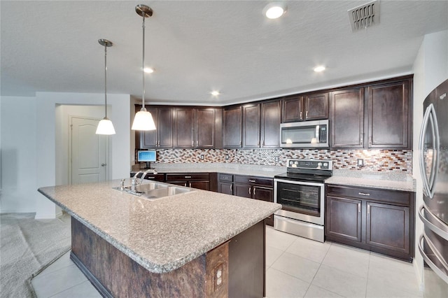 kitchen featuring appliances with stainless steel finishes, visible vents, a sink, and dark brown cabinetry