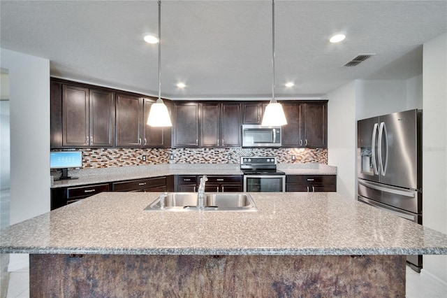 kitchen with stainless steel appliances, tasteful backsplash, visible vents, a sink, and dark brown cabinetry