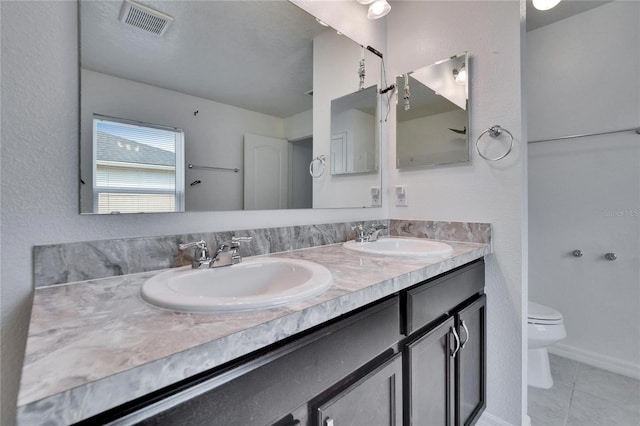 full bath with visible vents, a sink, toilet, and double vanity