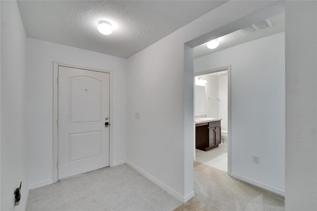 corridor with baseboards, visible vents, and a textured ceiling